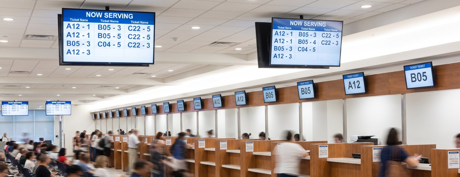 A licensing office with a screen above every counter position and now serving boards on the wall